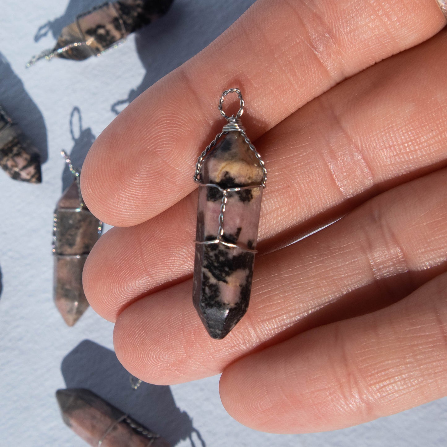 rhodonite, rhodonite pendant, rhodonite jewelry, crystal pendant, crystal jewelry, gemstone pendant, gemstone jewelry, rhodonite crystal, rhodonite stone, rhodonite properties, rhodonite healing properties, rhodonite metaphysical properties, rhodonite meaning